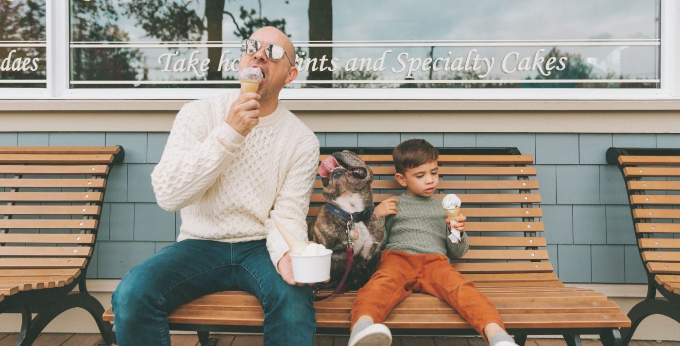 a-father-and-son-sitting-with-their-dog-on-a-bench-eating-ice-cream_t20_3QlN7A-e1574288064573