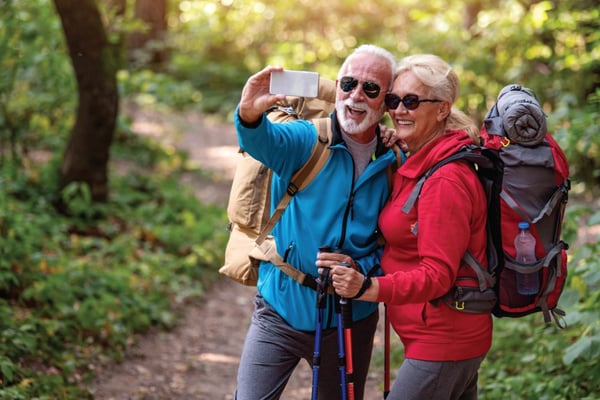 Old Married couple smiling for the camera on a hike