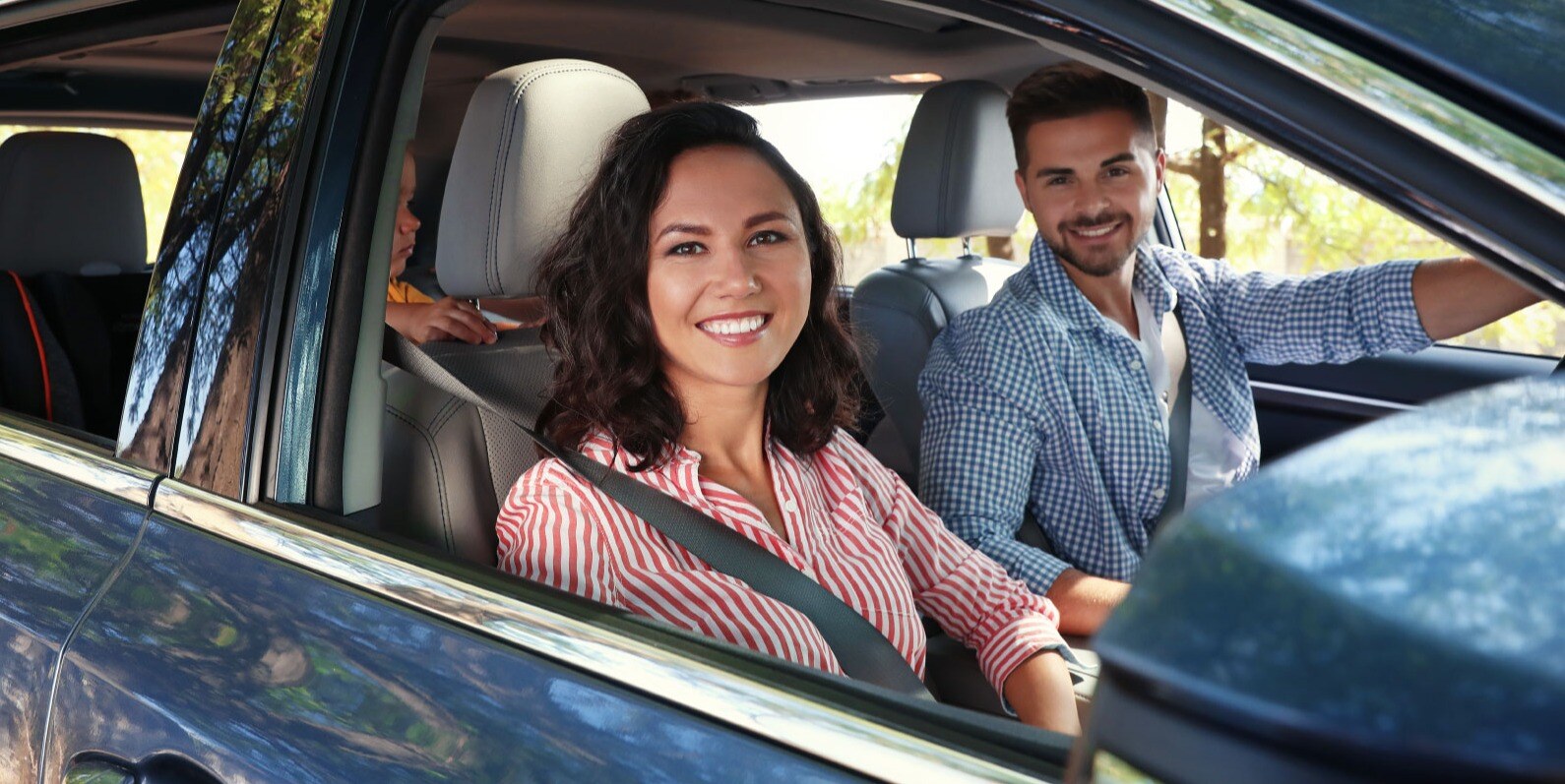 couple in new blue SUV with young child in the backseat