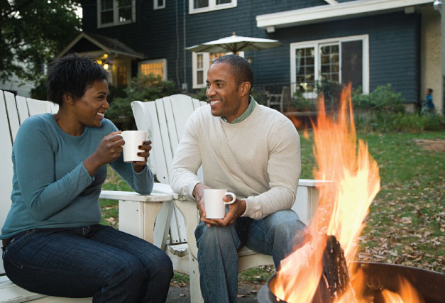 couple-sitting-by-firepit-in-their-backyard