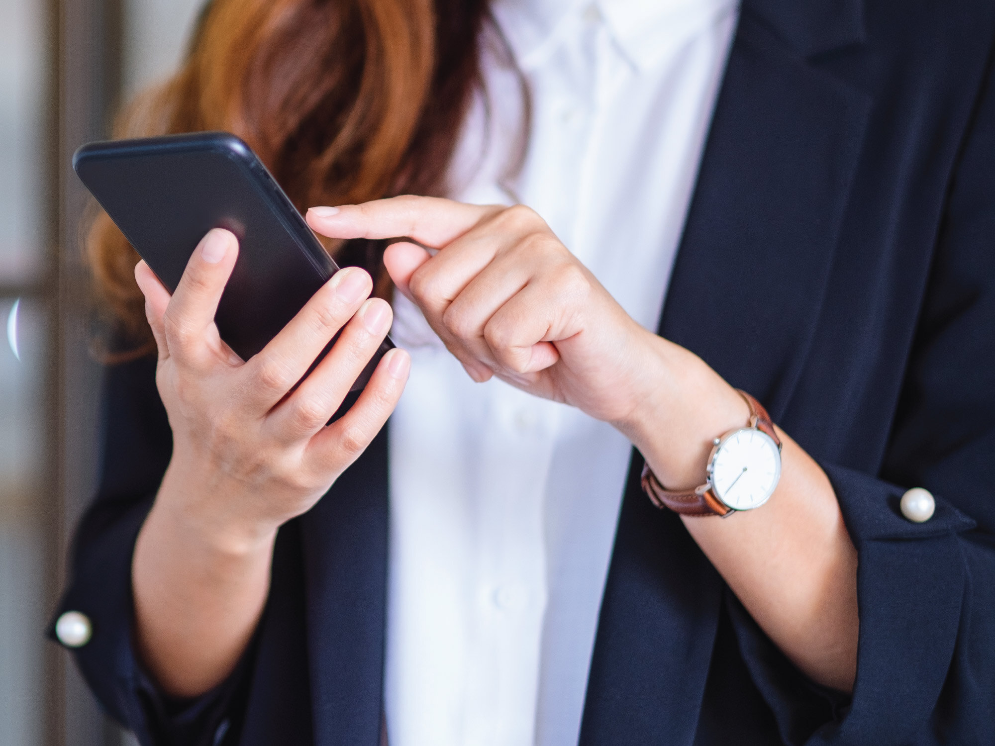 business women dialing a number on her cell phone