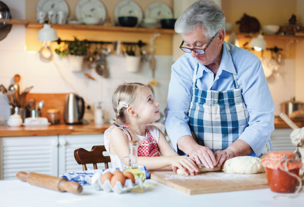 Grandparent teaching grandchild how to make bread