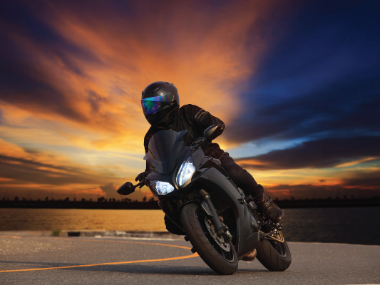 riding a motorcycle at sunset 