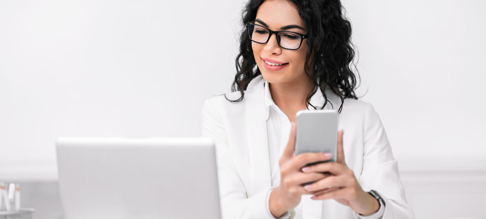 person looking at phone and laptop