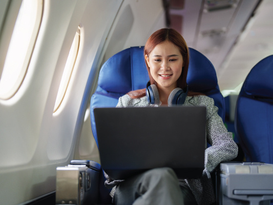 person with laptop on airplane