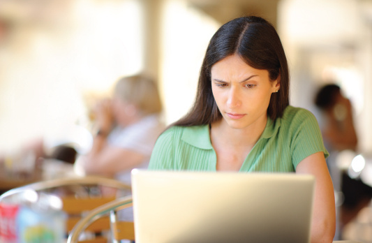 person looking at laptop suspiciously 
