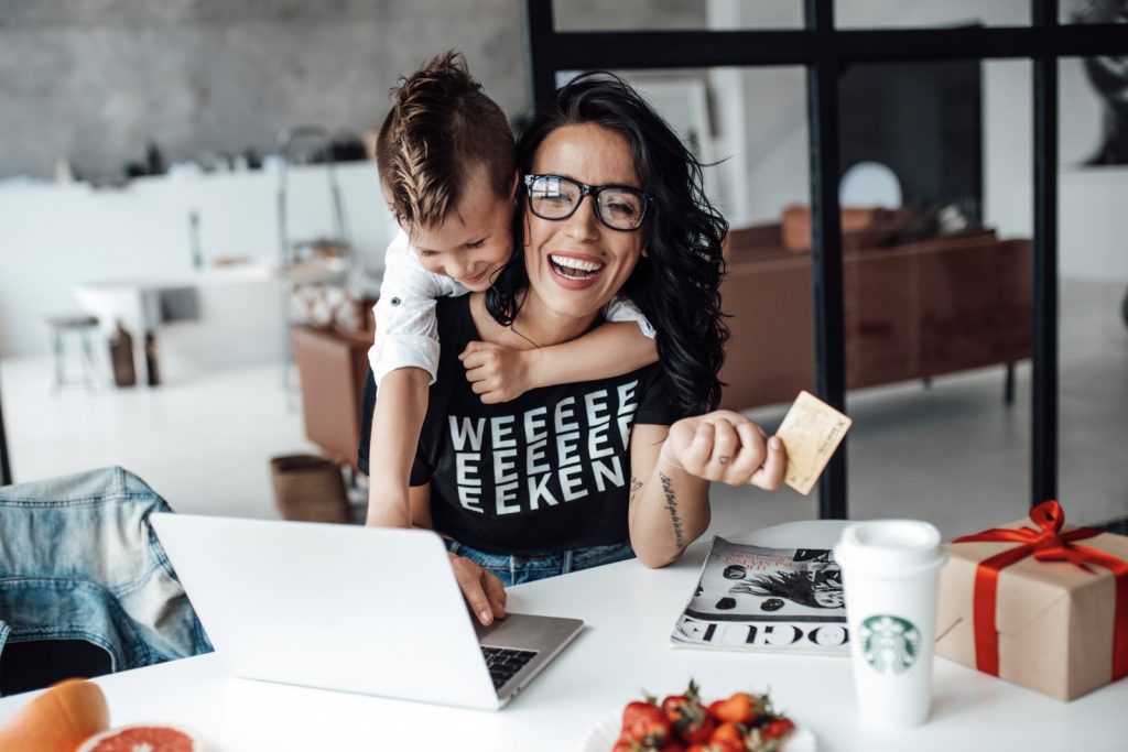 child hugging their mother while online shopping