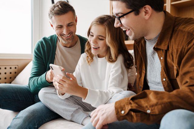 three people looking at phone