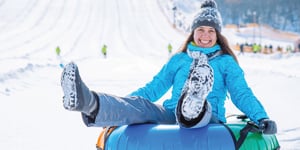 winter-person-happily-tubing-down-a-mountain