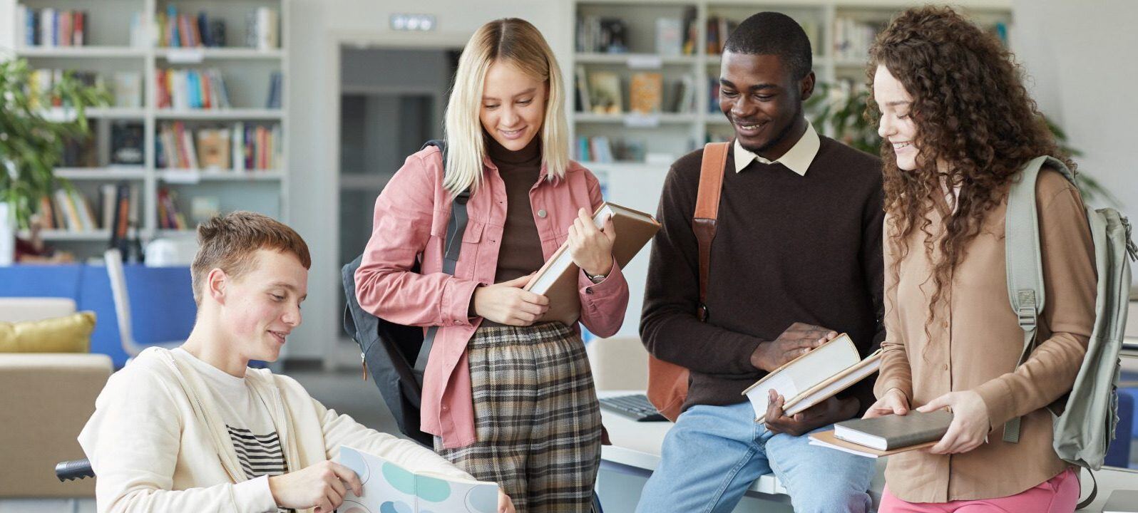 group of college students talking in the library