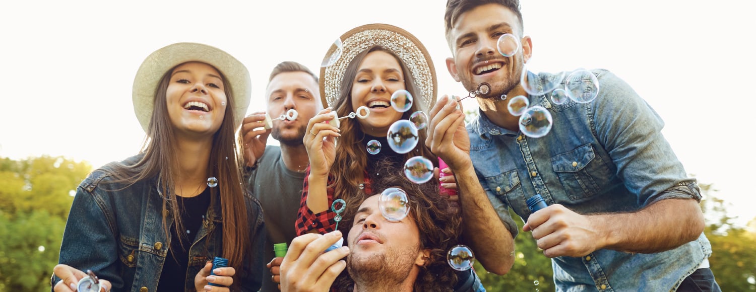 group of friends in the summer blowing bubbles and having fun