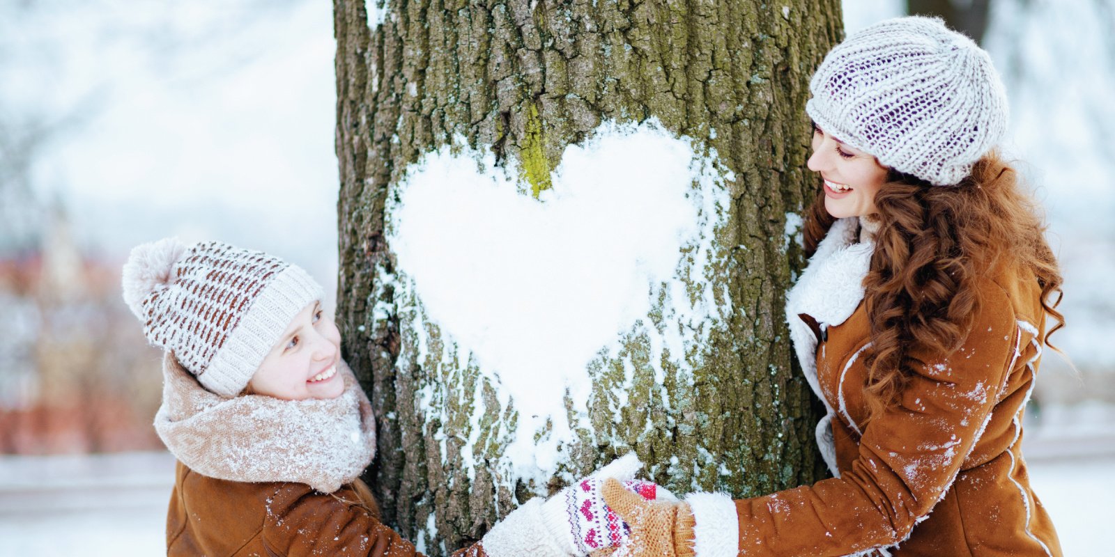 family hugging tree with snow heart