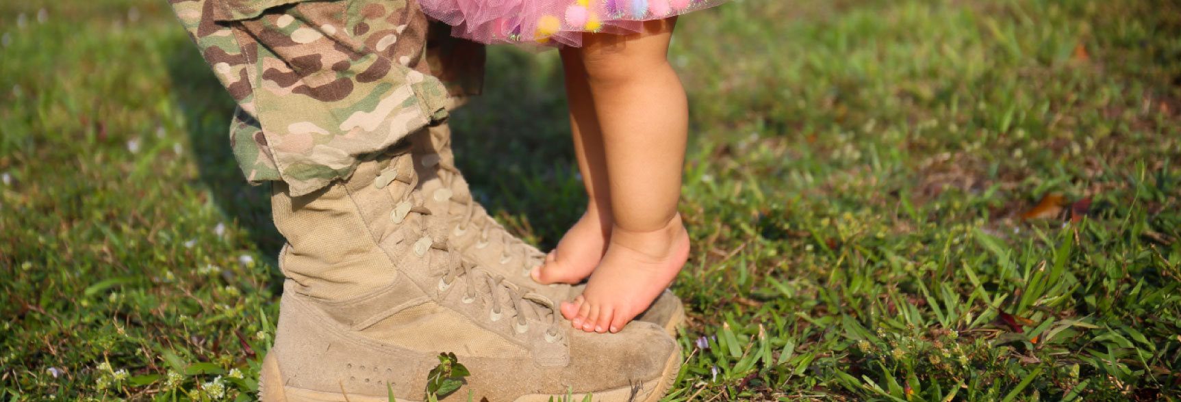toddler standing on per dad's military boots