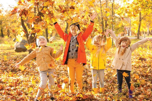 kids throwing leaves in the fall