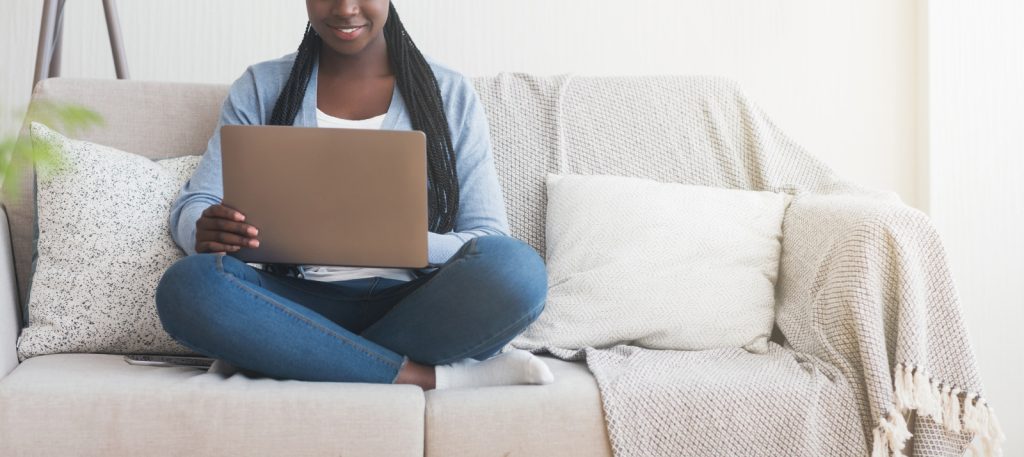 person sitting on couch at home using laptop