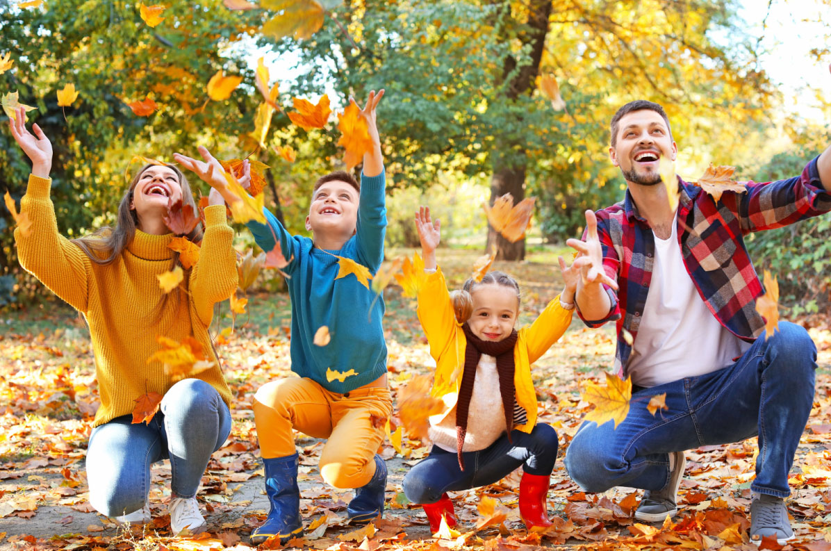 family playing with leaves in fall